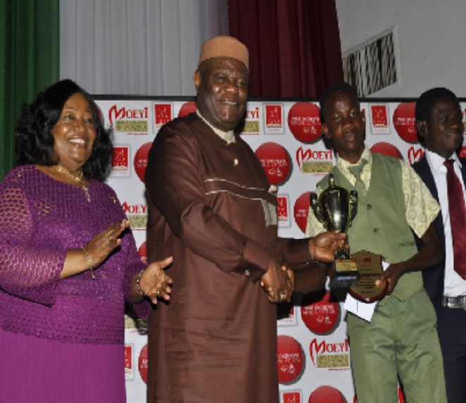 Bishp Peace Okonkwo, Bishop Mike Okonkwo handing over the star price and a trophy to the winner Esigbone Omagbemi Fredinand of 2019 Mike Okonkwo National Essay Competition