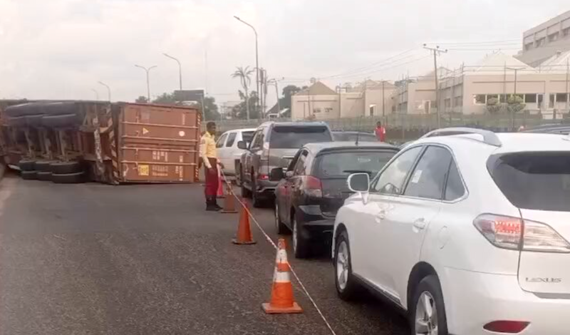 Many hooked in traffic as truck carrying container tumbles in Lagos